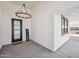 Modern entryway with a black door, elegant chandelier, and a welcoming 'Welcome' sign at 35597 W Jones Ave, Tonopah, AZ 85354