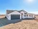 Single-story home with a gray garage door and a covered carport, all set on a spacious lot at 35597 W Jones Ave, Tonopah, AZ 85354