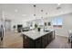 Open concept kitchen with a large island and pendant lighting with a view of the living area at 35597 W Jones Ave, Tonopah, AZ 85354