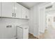 This laundry room features white shaker cabinets, modern hardware, and tile flooring at 35597 W Jones Ave, Tonopah, AZ 85354