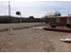 View of the gravel backyard with a basketball hoop and a wood deck for outdoor enjoyment at 409 S Mountain View Dr, Kearny, AZ 85137