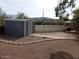 View of a storage shed and landscaping with a brick trim and a fenced backyard at 409 S Mountain View Dr, Kearny, AZ 85137