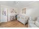 Bedroom with hardwood floors, white crib, changing table, and animal decor at 4826 N 34Th Pl, Phoenix, AZ 85018