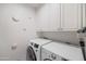 Laundry room boasts white cabinets above a front-load washer and dryer at 4826 N 34Th Pl, Phoenix, AZ 85018