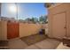 A private backyard featuring a concrete patio, wooden gate, and partial views of the surrounding neighborhood at 500 N Roosevelt Ave # 118, Chandler, AZ 85226