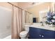 Cozy bathroom with shower-tub combo, tile floors, and a blue vanity at 500 N Roosevelt Ave # 118, Chandler, AZ 85226