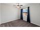 Cozy bedroom features a ceiling fan, neutral carpet, and a window with dark curtains at 5106 N 17Th Ave # 11, Phoenix, AZ 85015