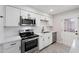 Updated kitchen featuring white cabinets, stainless steel appliances, and a door to the backyard at 5106 N 17Th Ave # 11, Phoenix, AZ 85015