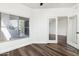 Bright bedroom with wood floors, large window, and glass doors at 600 W Grove Pkwy # 2188, Tempe, AZ 85283