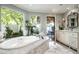 Bright bathroom with a soaking tub, marble counters, and a view to the outdoors at 6221 E Vista Dr, Paradise Valley, AZ 85253