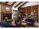 Warm living room with a wood-beamed ceiling, fireplace, rich wood details, and comfortable blue seating at 6221 E Vista Dr, Paradise Valley, AZ 85253