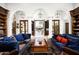 Elegant living room with white arches, dark wood shelving, and blue couches leading to a bright outdoor space at 6221 E Vista Dr, Paradise Valley, AZ 85253