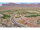 A high aerial view of a community showcasing the red tile roofs and desert golf course with mountain views at 7442 E Golden Eagle Cir, Gold Canyon, AZ 85118