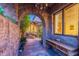 Arched stone entryway leads to a tranquil courtyard with a stone fountain and lush greenery at 7442 E Golden Eagle Cir, Gold Canyon, AZ 85118