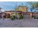 Well-lit exterior of the home with a desert landscape and a two-car garage at 7442 E Golden Eagle Cir, Gold Canyon, AZ 85118