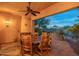 Covered patio with wood dining set, tile flooring, and views of the desert landscape at 7442 E Golden Eagle Cir, Gold Canyon, AZ 85118