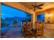 Elegant covered patio with dining set, built-in grill, and panoramic mountain views at 7442 E Golden Eagle Cir, Gold Canyon, AZ 85118