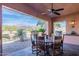 Cozy covered patio features ceiling fan and rustic wood dining table overlooking the landscape at 7442 E Golden Eagle Cir, Gold Canyon, AZ 85118