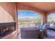 Relaxing covered patio with a fireplace and comfortable seating with mountain views at 7442 E Golden Eagle Cir, Gold Canyon, AZ 85118