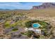 Aerial view of a community pool with clubhouse, tennis courts, and desert landscaping against a backdrop of mountains at 7442 E Golden Eagle Cir, Gold Canyon, AZ 85118