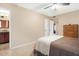 Neutral bedroom with ceiling fan, door to bathroom, closet, and view into the hallway at 9501 W Hidden Valley Cir, Sun City, AZ 85351