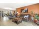 Open-concept living room with modern furniture, an eye-catching accent wall, and tile flooring at 9501 W Hidden Valley Cir, Sun City, AZ 85351