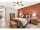 A well-lit bedroom with a large bed, dresser, and an accent wall with a ceiling fan at 9501 W Hidden Valley Cir, Sun City, AZ 85351