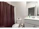 Clean bathroom featuring a modern vanity, toilet, and tiled shower with a brown curtain at 9509 W Illini St, Tolleson, AZ 85353