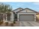 Attractive home featuring a two-car garage, neutral stucco, and easy-care desert landscaping at 9509 W Illini St, Tolleson, AZ 85353