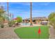 Landscaped backyard featuring a pool, putting green, and mature trees at 9517 W Cedar Hill Cir # N, Sun City, AZ 85351