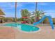 Sparkling pool with a slide, lounge chairs, and lush palm trees at 9517 W Cedar Hill Cir # N, Sun City, AZ 85351