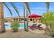 Backyard pool featuring lounge chairs, mature palm trees, and an outdoor entertaining area at 9517 W Cedar Hill Cir # N, Sun City, AZ 85351