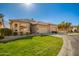 Beautiful single-story home with lush green lawn and a three car garage at 9617 E Holiday Way, Sun Lakes, AZ 85248