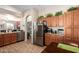 Well-lit kitchen with wood cabinets, stainless steel appliances, granite countertops, and wood-look tile flooring at 9617 E Holiday Way, Sun Lakes, AZ 85248