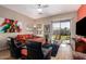 Cozy living room with modern ceiling fan, comfortable seating, and sliding door to backyard at 9617 E Holiday Way, Sun Lakes, AZ 85248