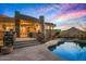 Stunning home exterior features a pool, stone accents, desert landscaping, and breathtaking mountain views at 9962 E Groundcherry Ln, Scottsdale, AZ 85262