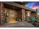 Elegant front entrance with double doors, potted plants, and desert landscaping at 9962 E Groundcherry Ln, Scottsdale, AZ 85262