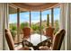 Bright game room featuring a desert view and four comfortable chairs around a dark wood table at 9962 E Groundcherry Ln, Scottsdale, AZ 85262