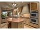 Warm kitchen features stainless steel appliances, a large island, and a view of the desert landscape at 9962 E Groundcherry Ln, Scottsdale, AZ 85262