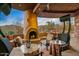 Covered patio with an outdoor fireplace, a ceiling fan, heat lamps, and comfortable seating at 9962 E Groundcherry Ln, Scottsdale, AZ 85262