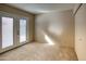 Bright bedroom with neutral carpet, closet, and direct access to the outdoor area through French doors at 10236 E Minnesota Ave, Sun Lakes, AZ 85248
