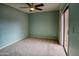 Inviting bedroom with a ceiling fan, plush carpet, and sliding glass doors that lead to an outdoor area at 10236 E Minnesota Ave, Sun Lakes, AZ 85248