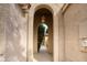 Arched entryway featuring a decorative light fixture and a glimpse of the front yard landscaping at 10236 E Minnesota Ave, Sun Lakes, AZ 85248