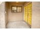 Inviting front porch with a bright yellow double door and textured stucco walls at 10236 E Minnesota Ave, Sun Lakes, AZ 85248