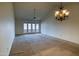 Spacious, carpeted living room with a ceiling fan, decorative lighting and sliding glass doors at 10236 E Minnesota Ave, Sun Lakes, AZ 85248
