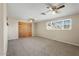 Inviting bedroom featuring dual ceiling fans, and natural light from the large window at 10324 N 97Th Dr # B, Peoria, AZ 85345