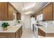 Well-lit kitchen with white appliances, wood cabinets, and tiled floors for a classic design at 10324 N 97Th Dr # B, Peoria, AZ 85345