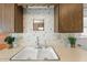 Close-up of the kitchen sink, light countertops and backsplash with wood cabinets at 10324 N 97Th Dr # B, Peoria, AZ 85345