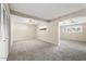 Large living room area with plush carpeting and a ceiling fan, providing ample space for relaxation at 10324 N 97Th Dr # B, Peoria, AZ 85345