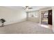 Bright living room featuring neutral walls, plush carpeting, ceiling fan and a welcoming entryway at 10324 N 97Th Dr # B, Peoria, AZ 85345